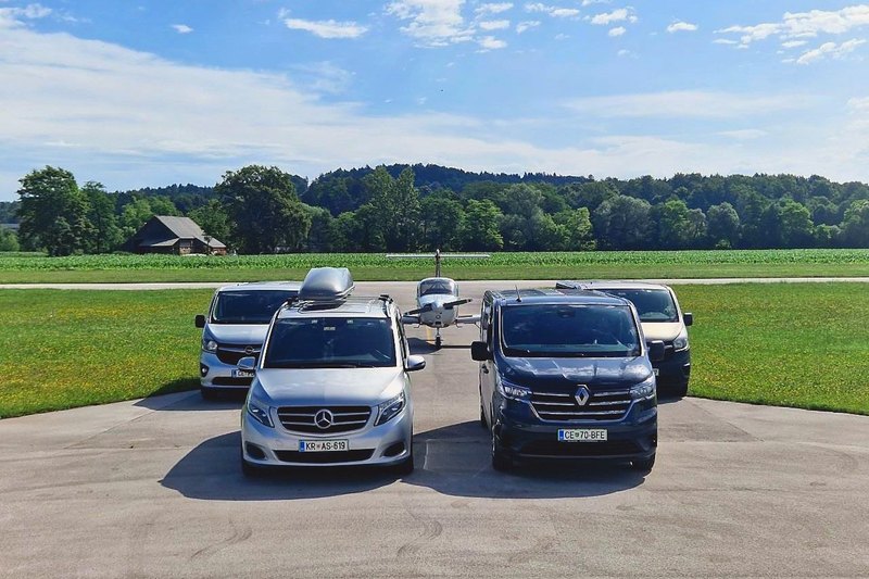 Mercedes V-Class and Renault Trafic at an airfield, with two more minibuses and an aircraft behind them