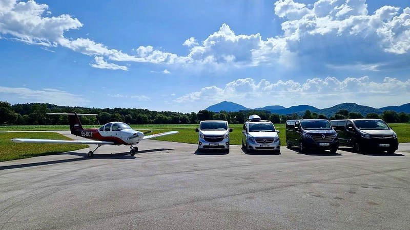 An aircraft and four TourSlo minibuses in a row on the airfield apron