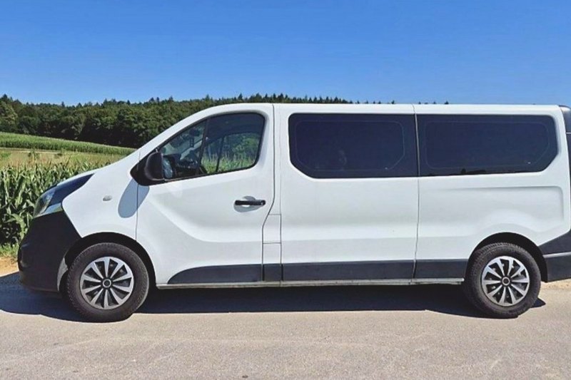 White Opel Vivaro from the side, on a road by a cornfield